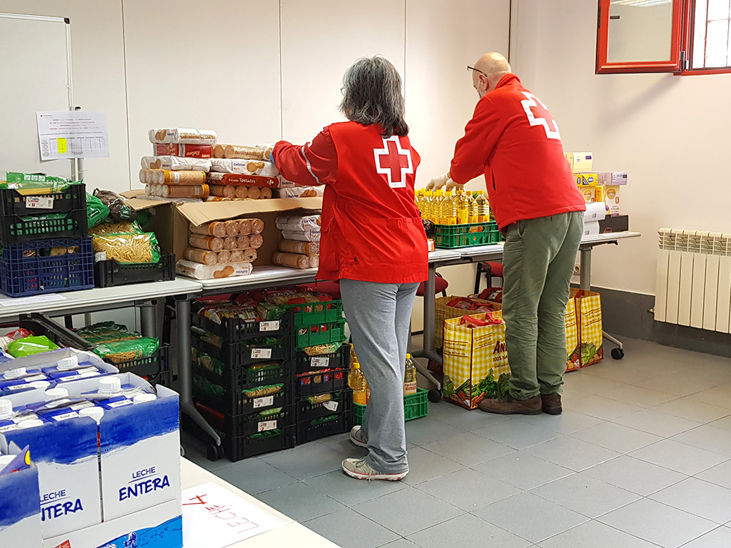 Dos voluntarios participan en labores de reparto de comida