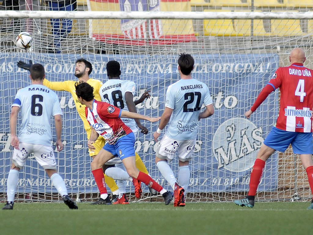 Carmona intenta alcanzar el remate de Miki Muñoz en la acción que supuso el primer gol del Navalcarnero que empataba el encuentro. / JUAN MARTÍN-G. SEGOVIANA