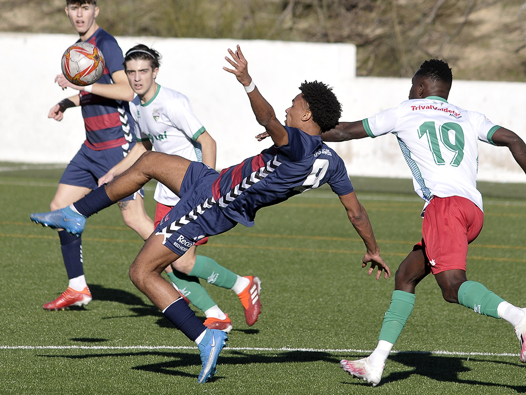 Encho despeja el balón ante la presión de un contrario en un momento del partido./ JUAN MARTÍN-G. SEGOVIANA