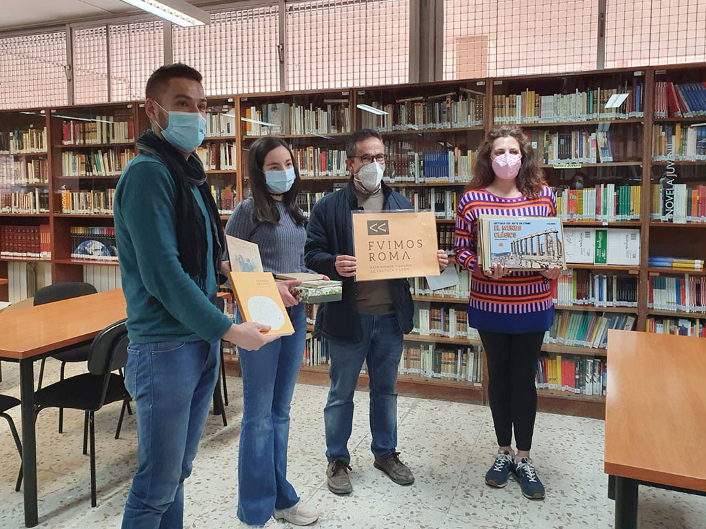 La joven obtiene el premio de la mano de dos representantes del proyecto para la difusión del patrimonio romano. / E.A.
