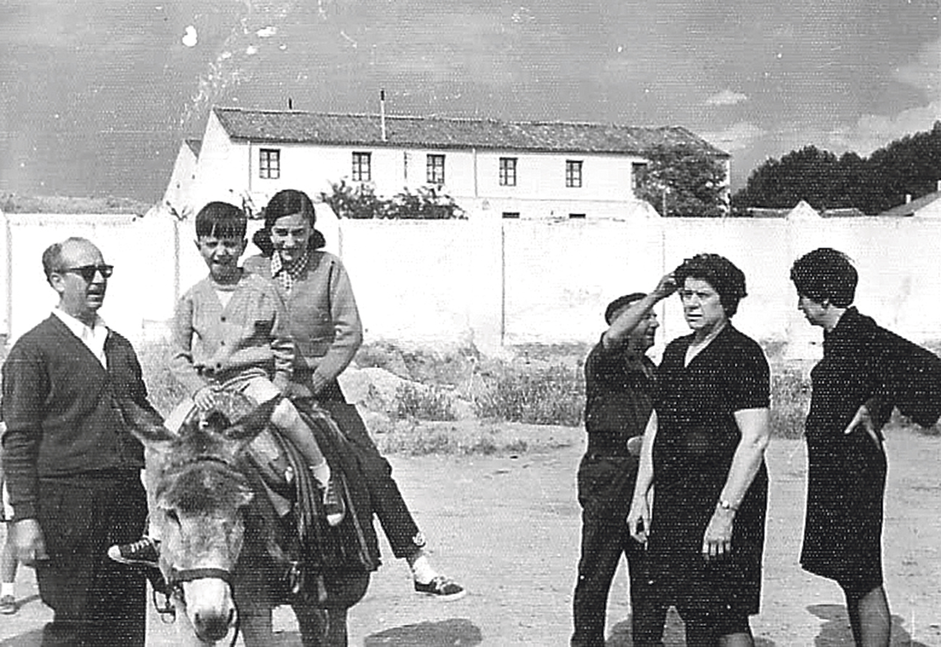 El Guarda Valentín llega al caño junto a su burro, conversa con unos vecinos y unos niños suben al animal. Álvaro Pinela.