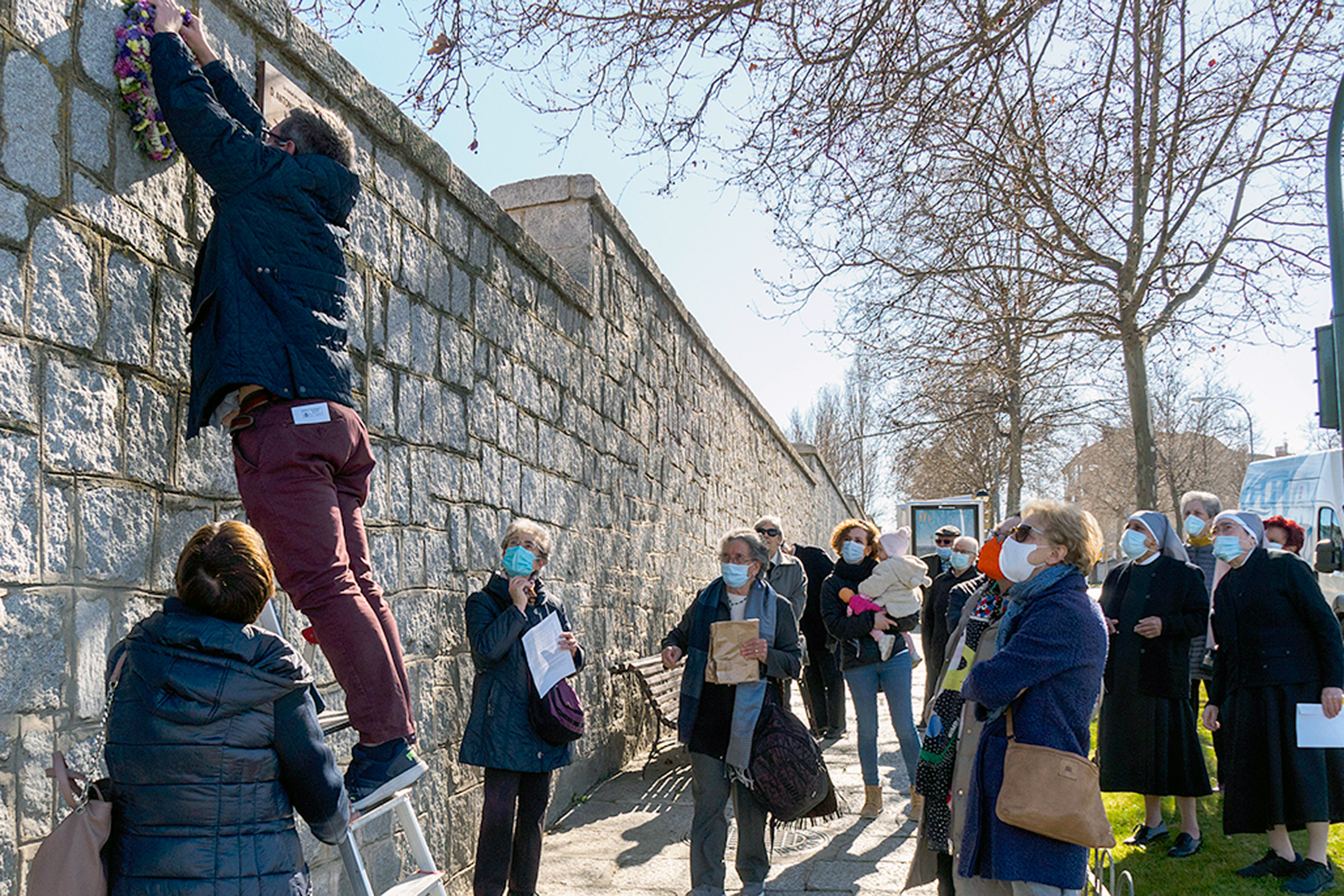 Asistentes a la ofrenda floral junto a la placa que atestigua su recuerdo en las Hermanitas de los Pobres. /KAMARERO