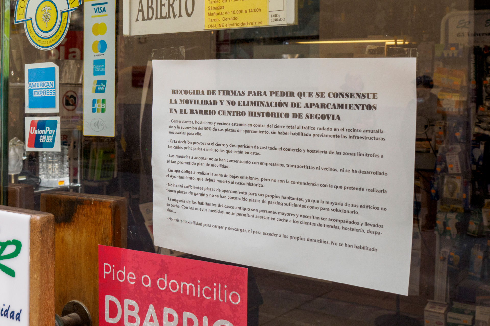 Uno de los carteles que anima a la recogida de firmas en el escaparate de un establecimiento. / Kamarero