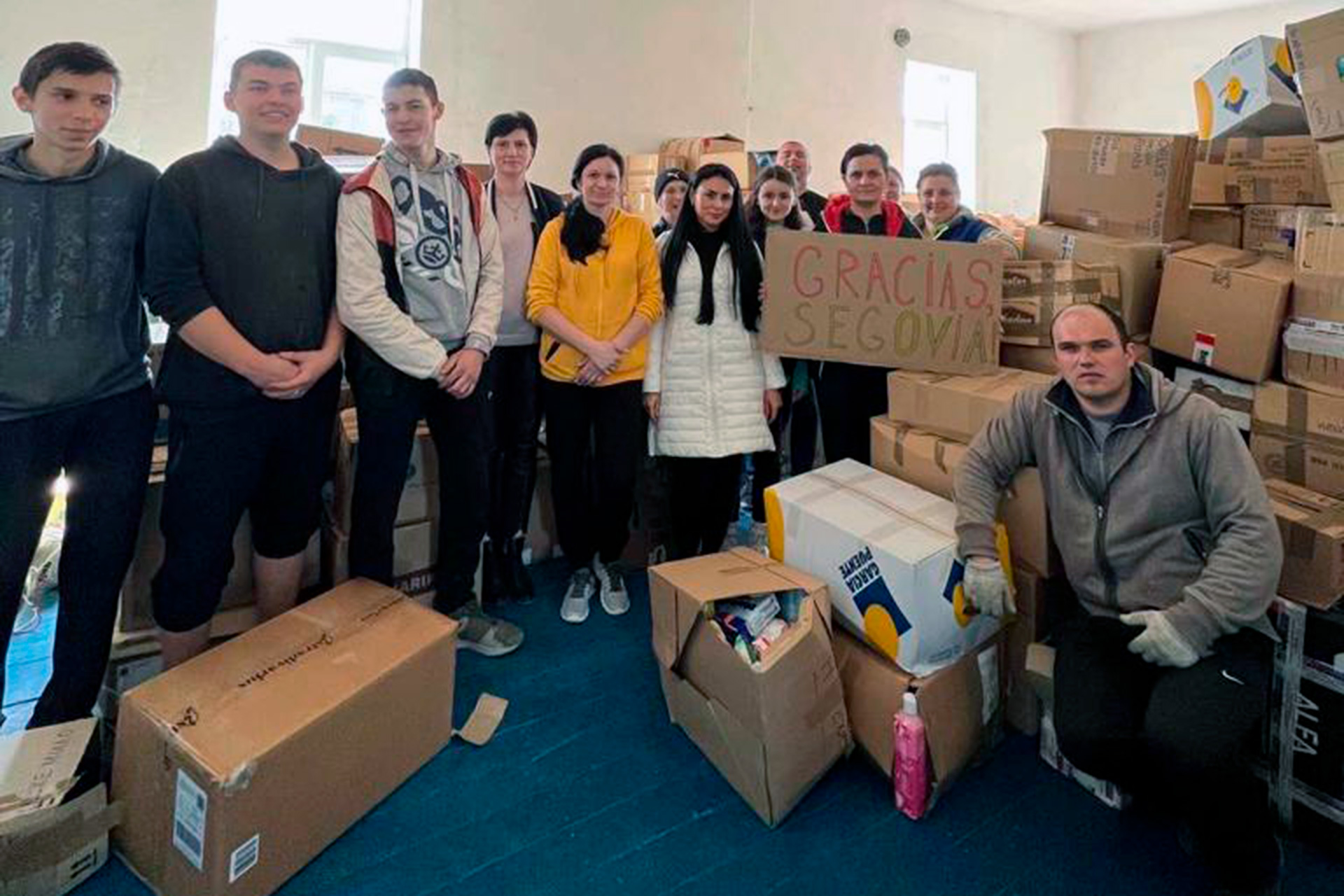 Vecinos de la localidad ucraniana de Kamianske junto al material recibido y un cartel que dice ‘Gracias Segovia’. / E. A.