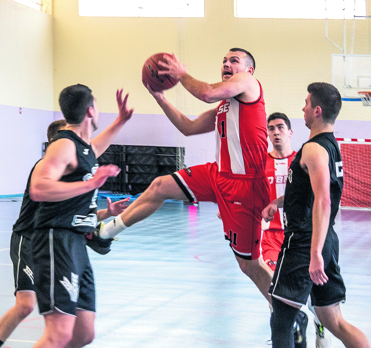 Alberto Miguel se eleva entre tres jugadores del Soria Baloncesto buscando el aro./ NEREA LLORENTE