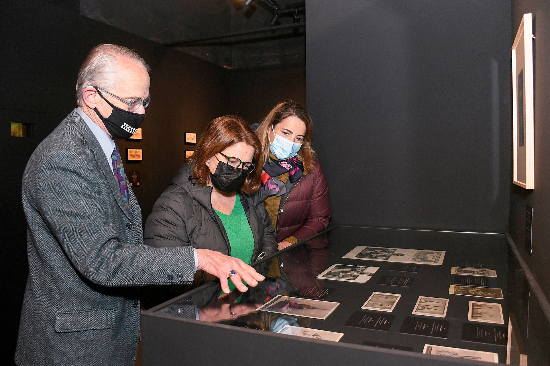 Vista de la muestra, en la Real Fábrica de Cristales, ante la mirada de tres visitantes. / EFE