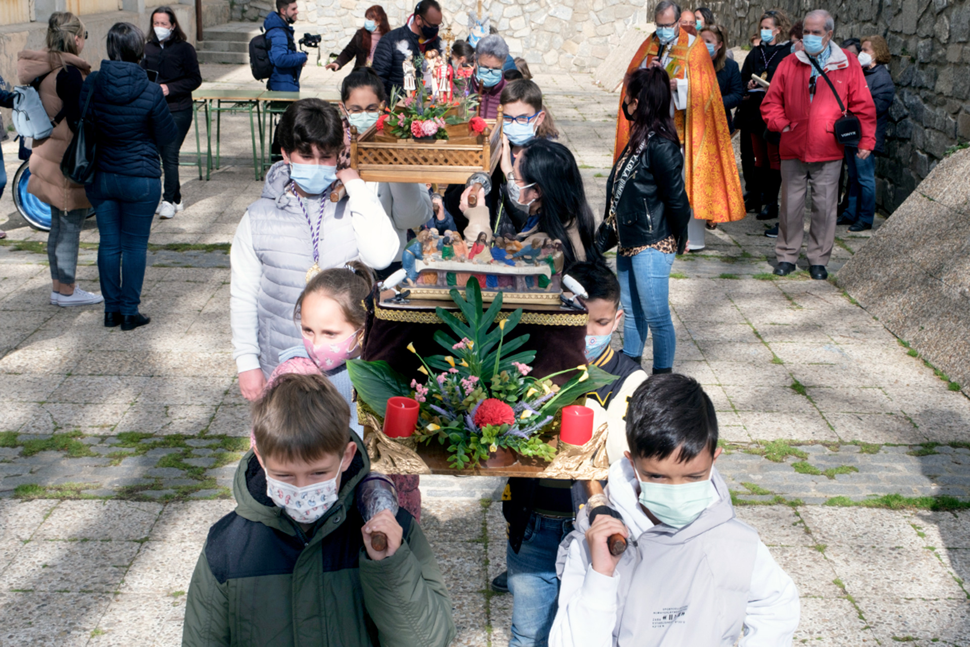 Los niños llevaron en andas las imágenes de la Semana Santa por las calles del barrio. / KAMARERO
