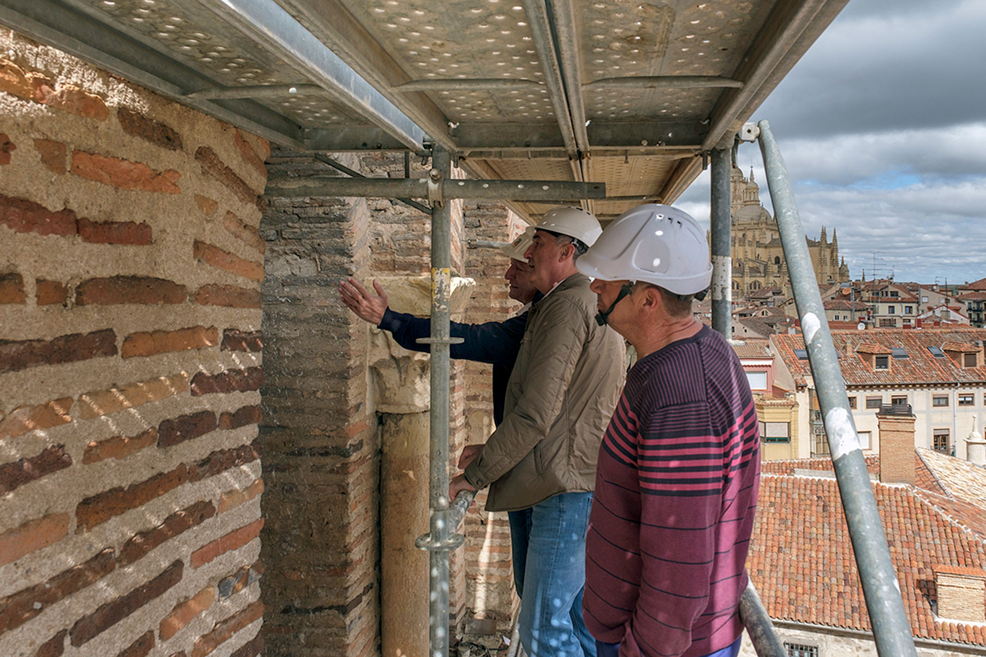 El delegado, en el centro, atiende explicaciones sobre los trabajos ya realizados en la iglesia románica. / Kamarero