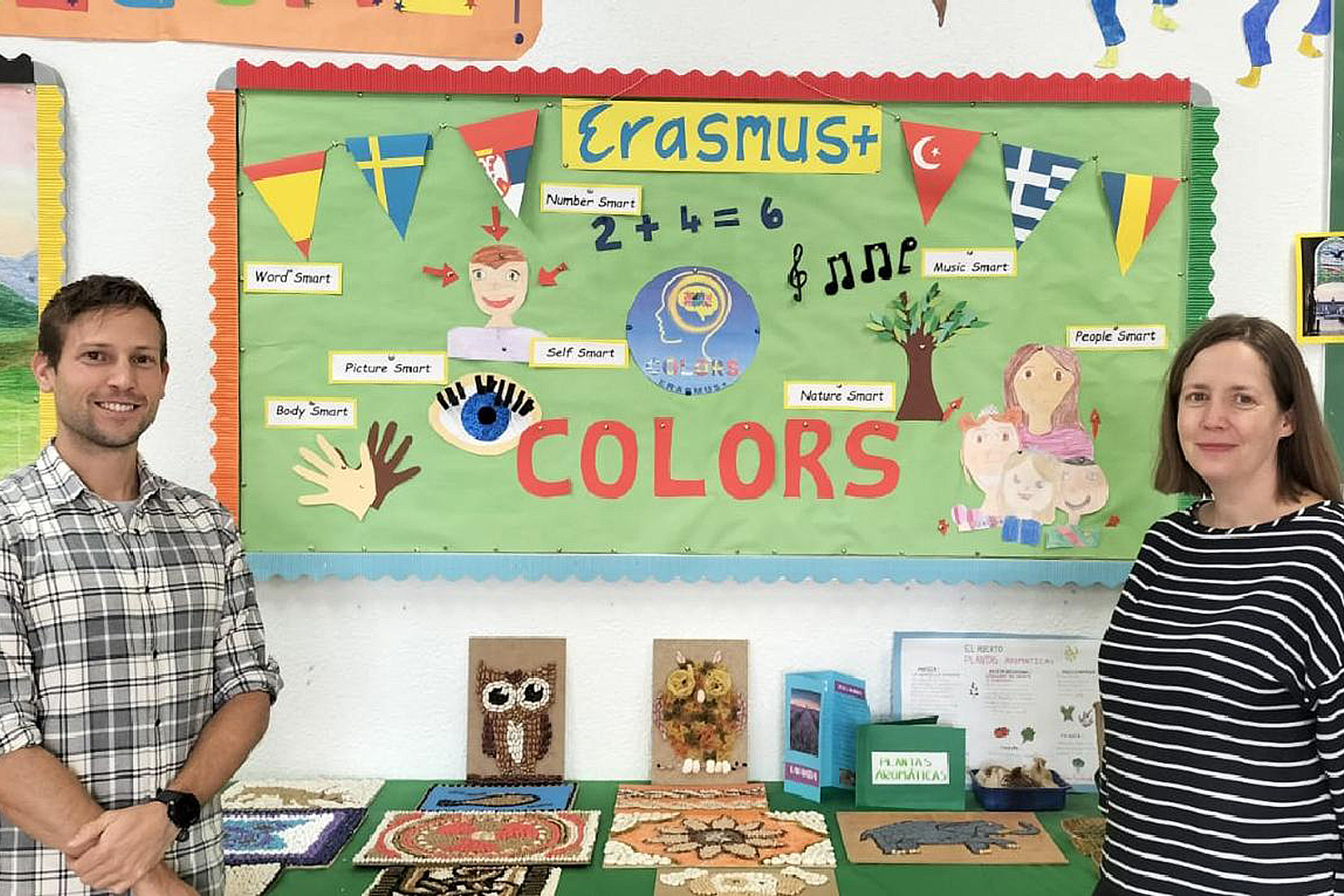 Maestros posando ante un panel que representa los objetivos y participantes del proyecto ‘Colors’. /EA