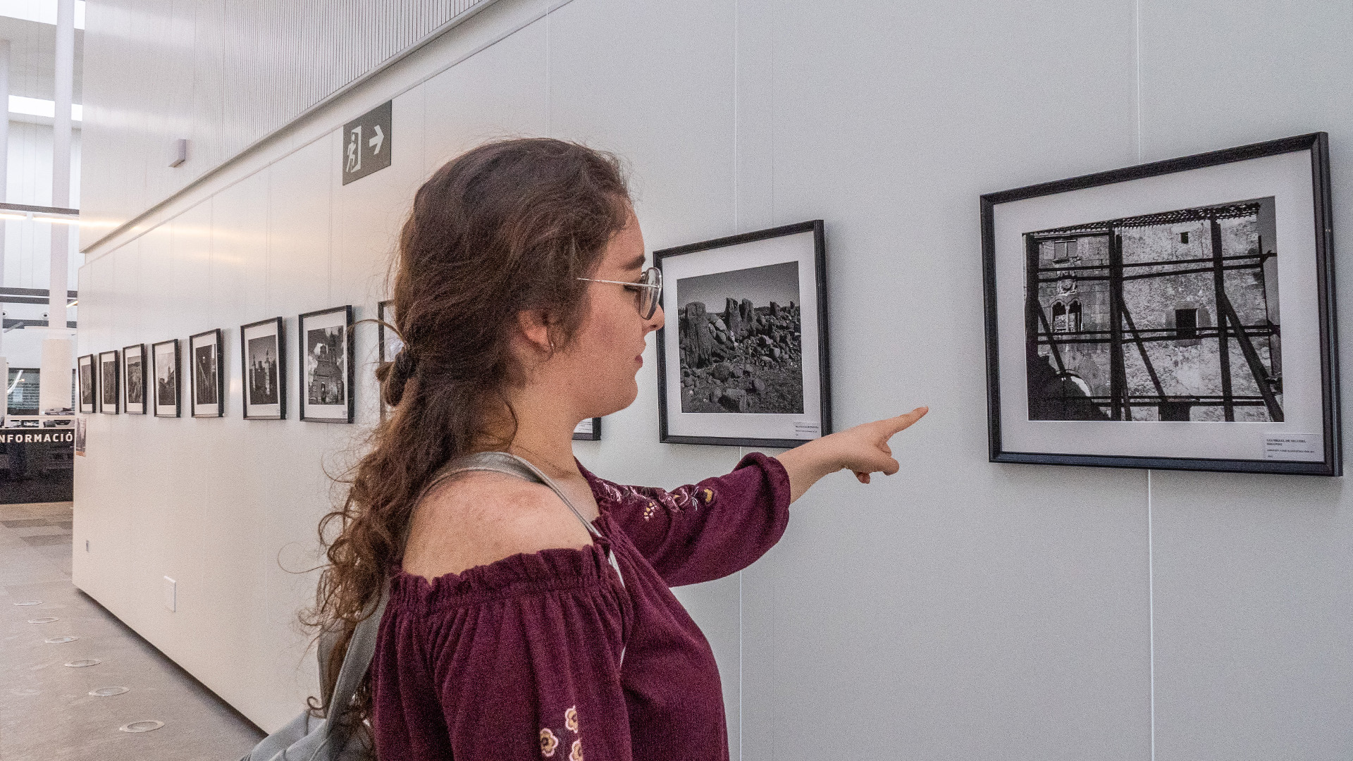 Una joven señala la fotografía que retrata el despoblado de San Miguel de Neguera, perteneciente a Sebúlcor, uno de los ejemplos de pueblos abandonados en la provincia. / NEREA LLORENTE