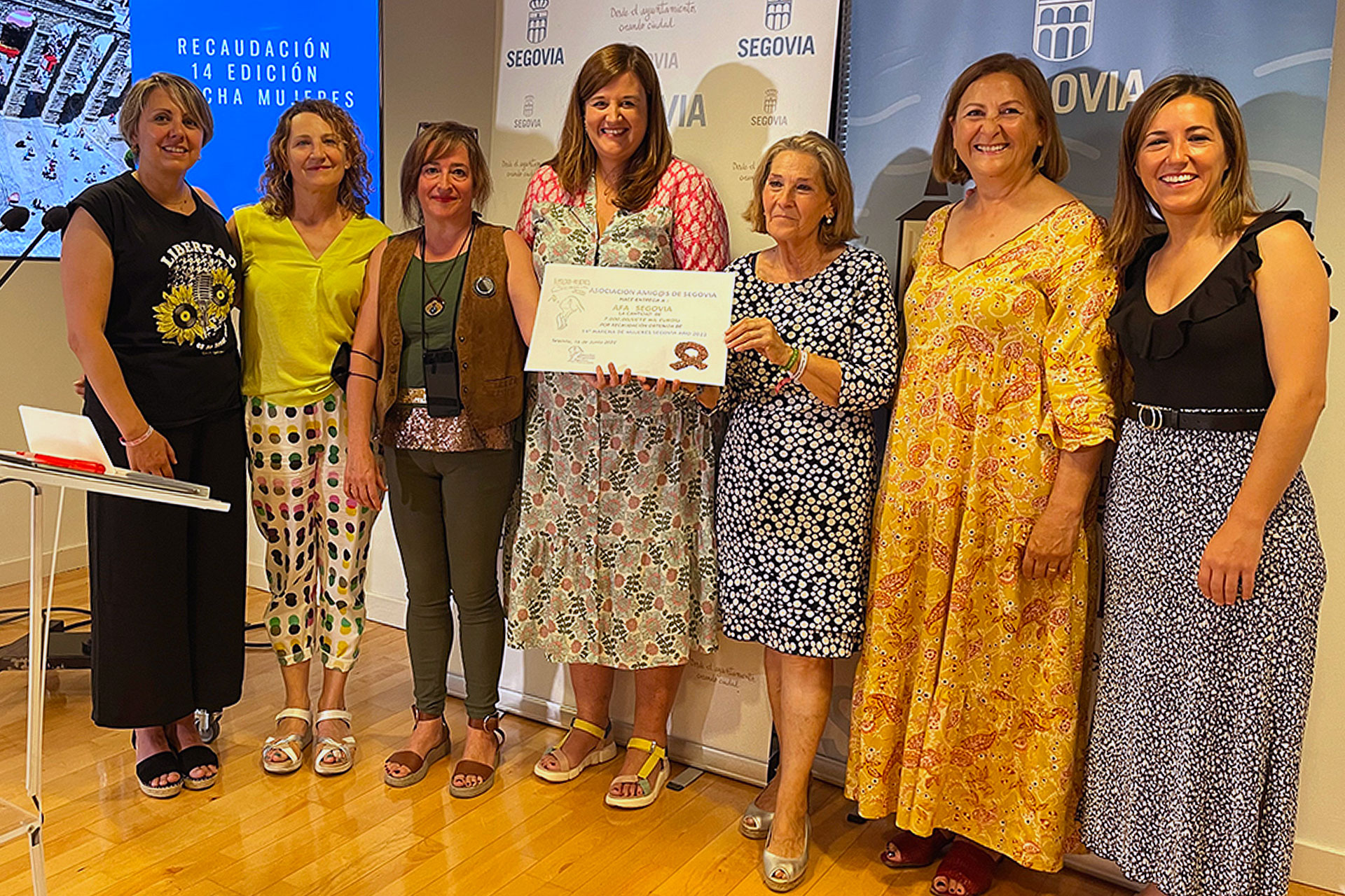 La alcaldesa, junto a miembros de la AFA y del ente organizador, sostiene el cheque de la ayuda.