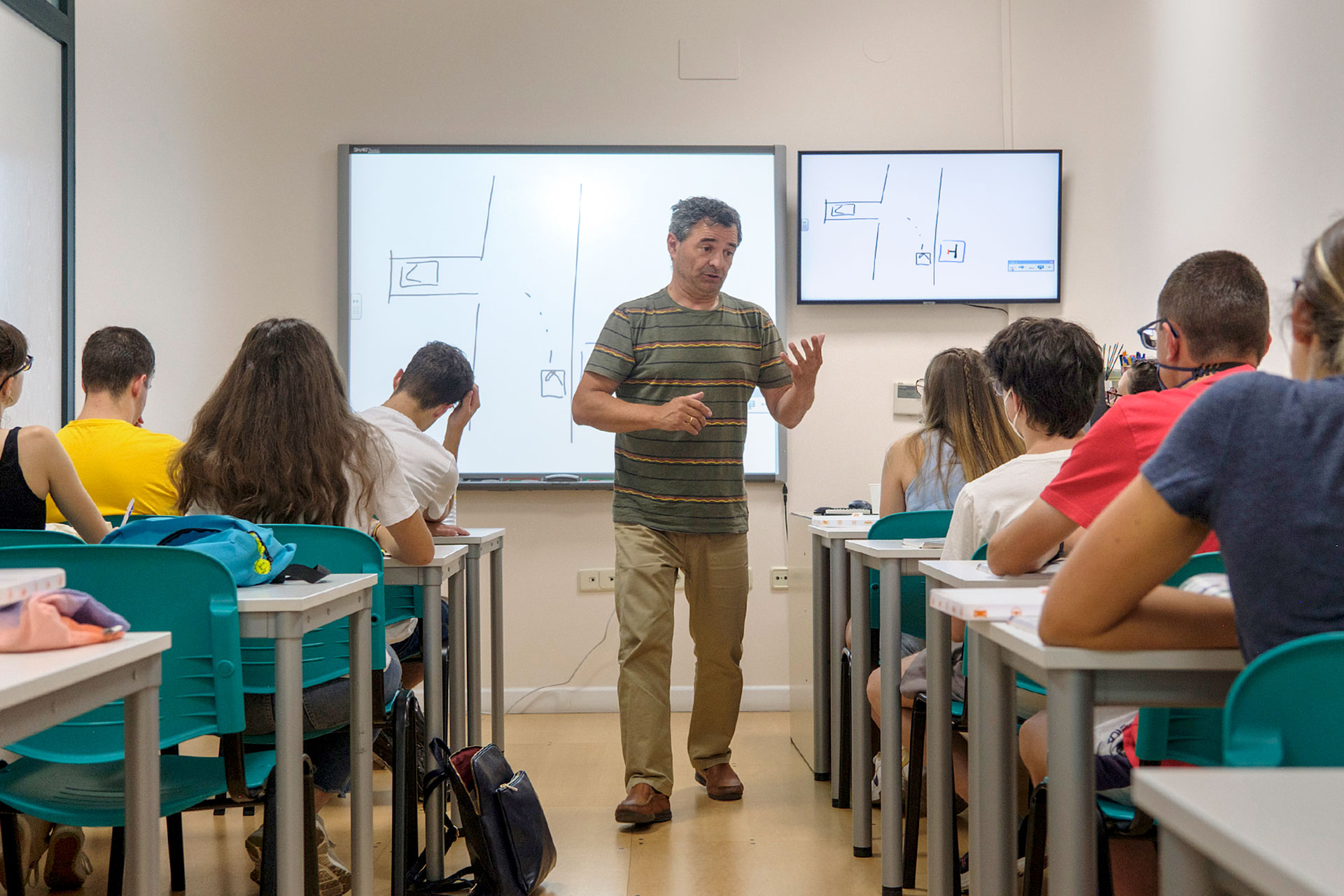 Profesor de autoescuela dando una clase teórica para preparar a sus alumnos para el examen. / KAMARERO