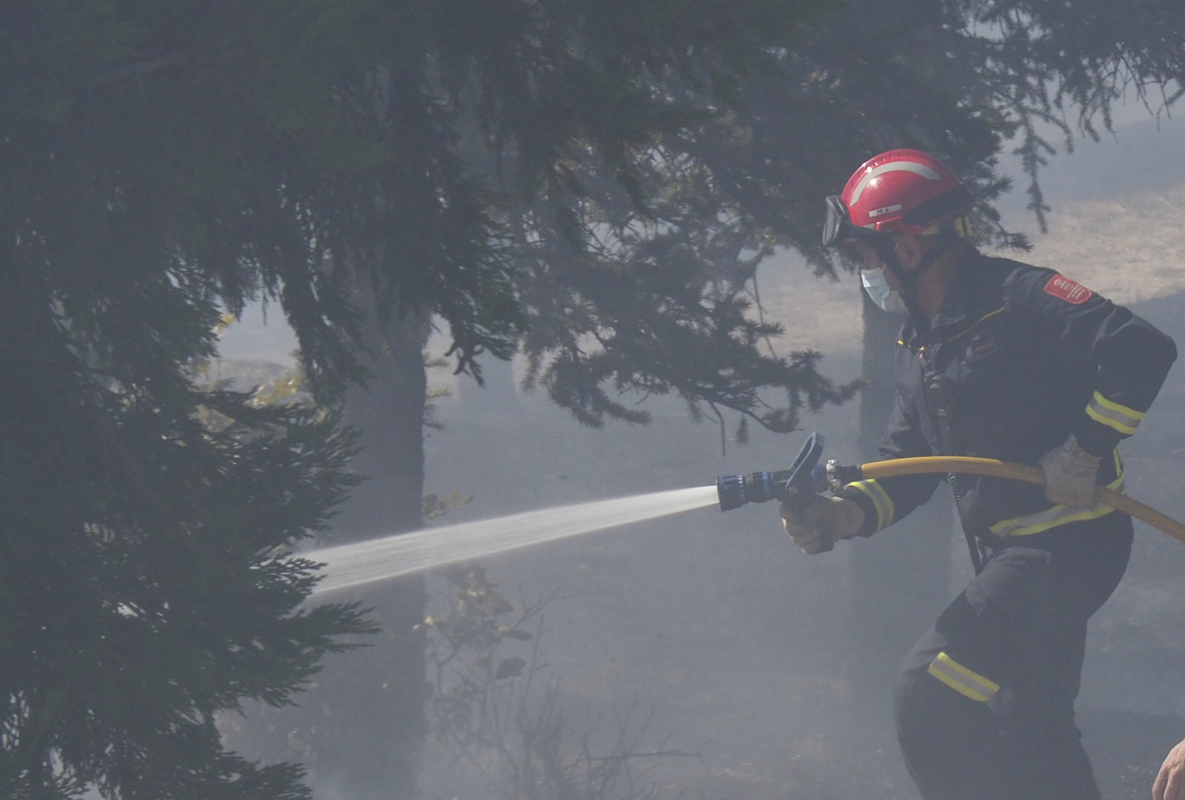 Un bombero, durante las labores de extinción de un incendio. / KAMARERO