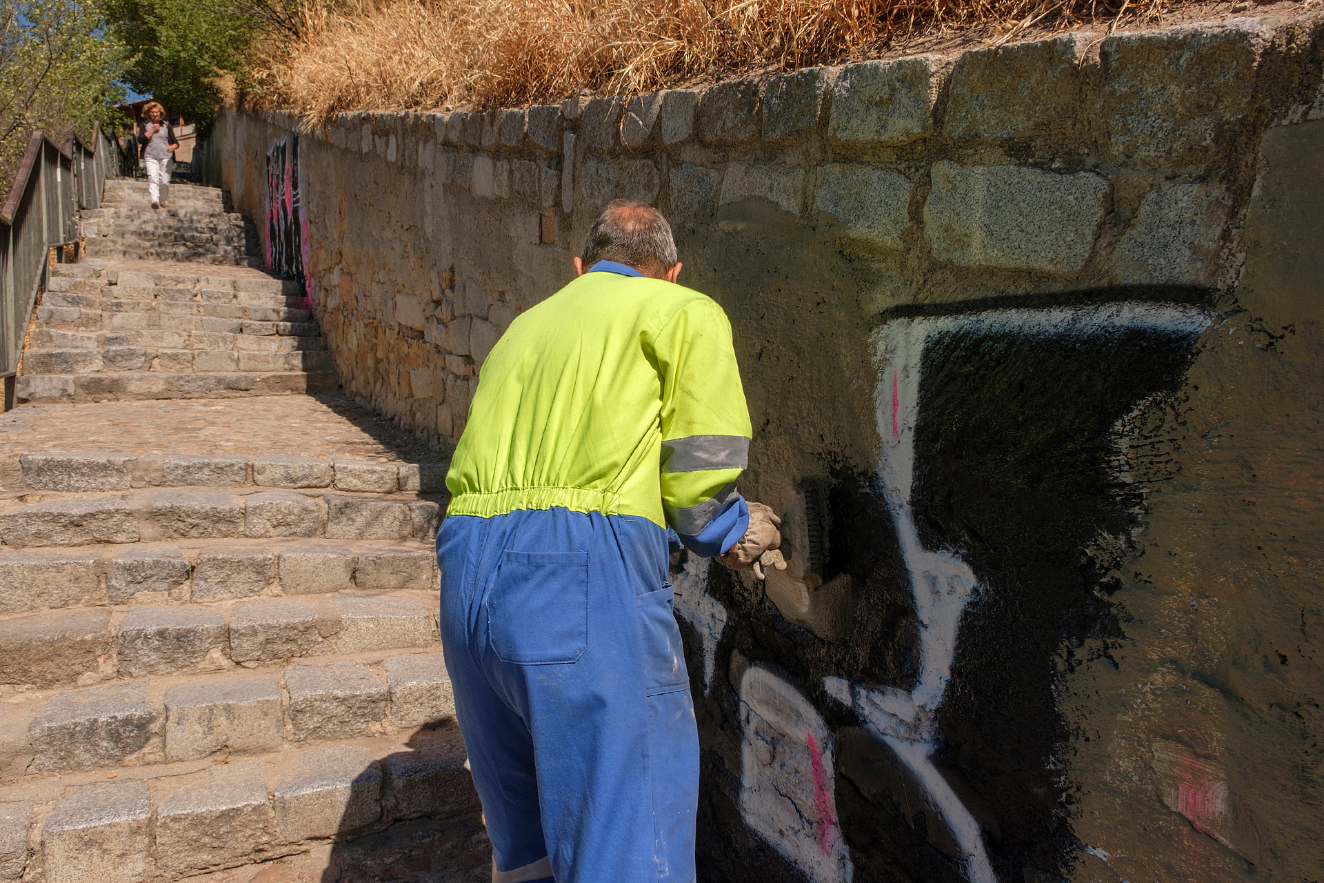 Uno de los operarios aplica cemento en una pintura. / Kamarero