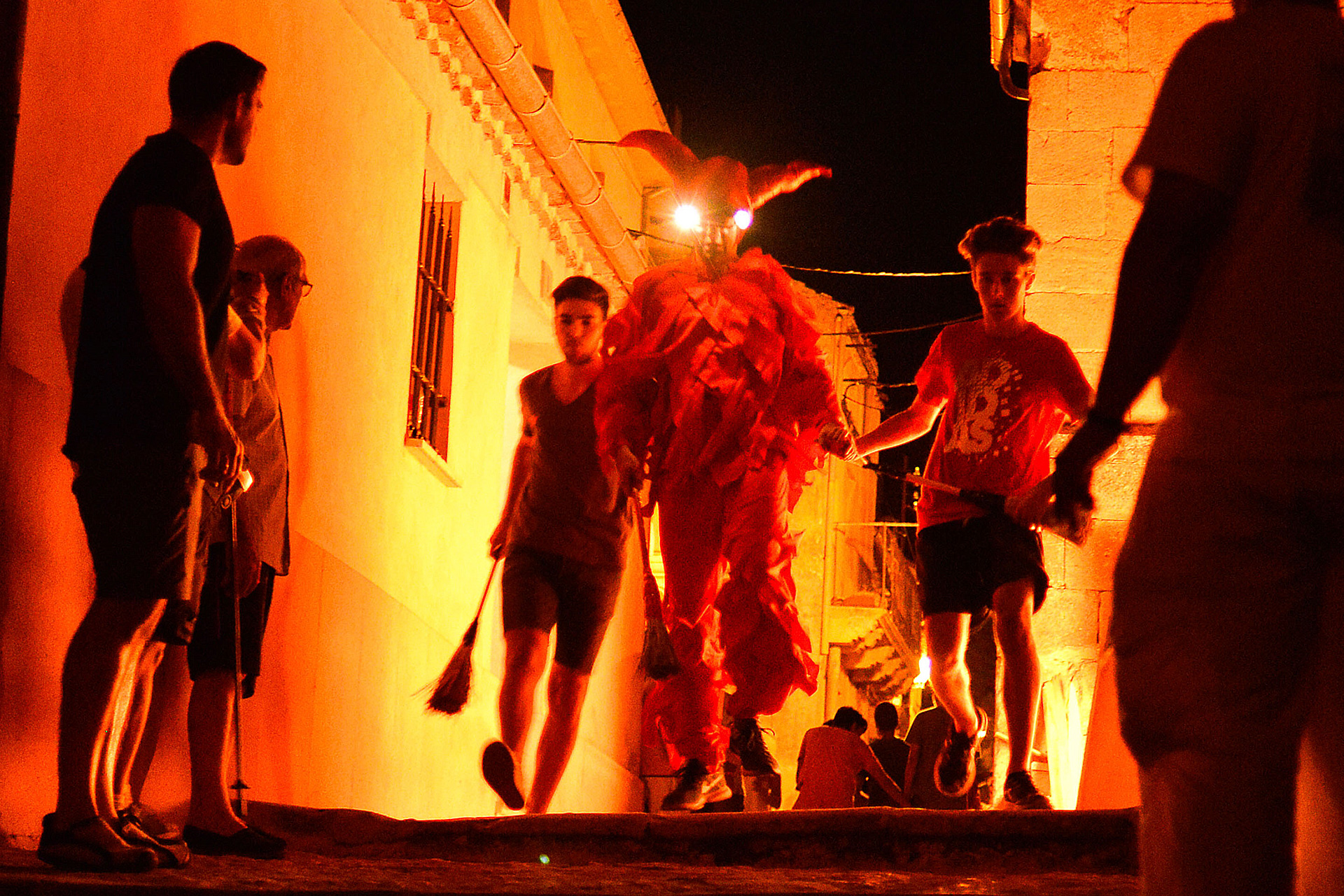 El Diablillo tiene un escolta a cada lado que también van dando escobazos a los asistentes. /E.A.