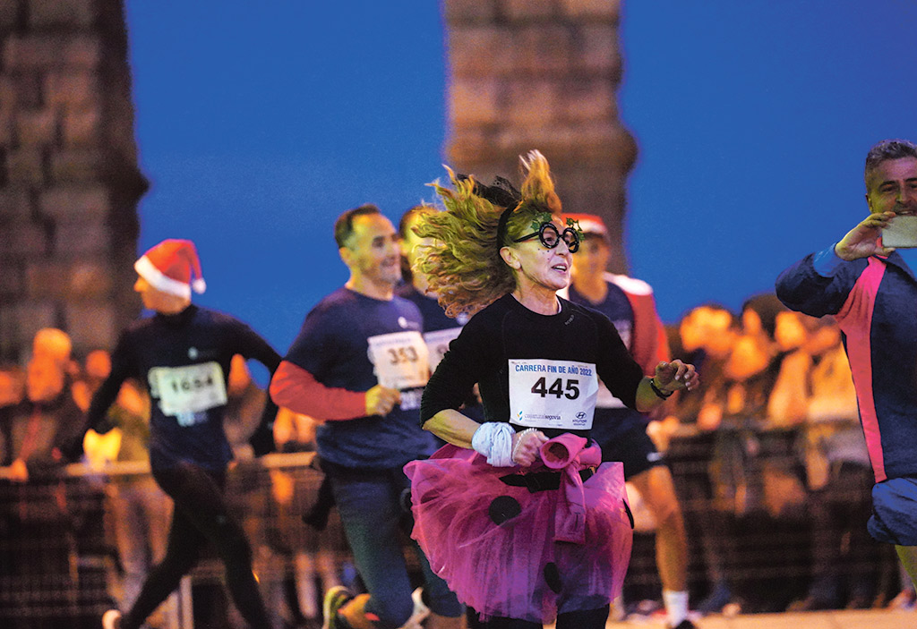 Una de las atletas disfrazada, pasando el Azoguejo. / MIGUEL ÁNGEL FERNÁNDEZ