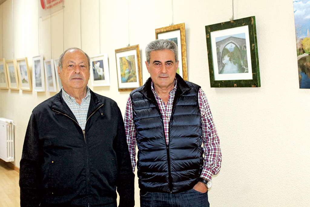 Federico de la Vega y Pablo Gómez posan en la exposición del Centro Social Corpus junto a algunas de sus obras./M.G.