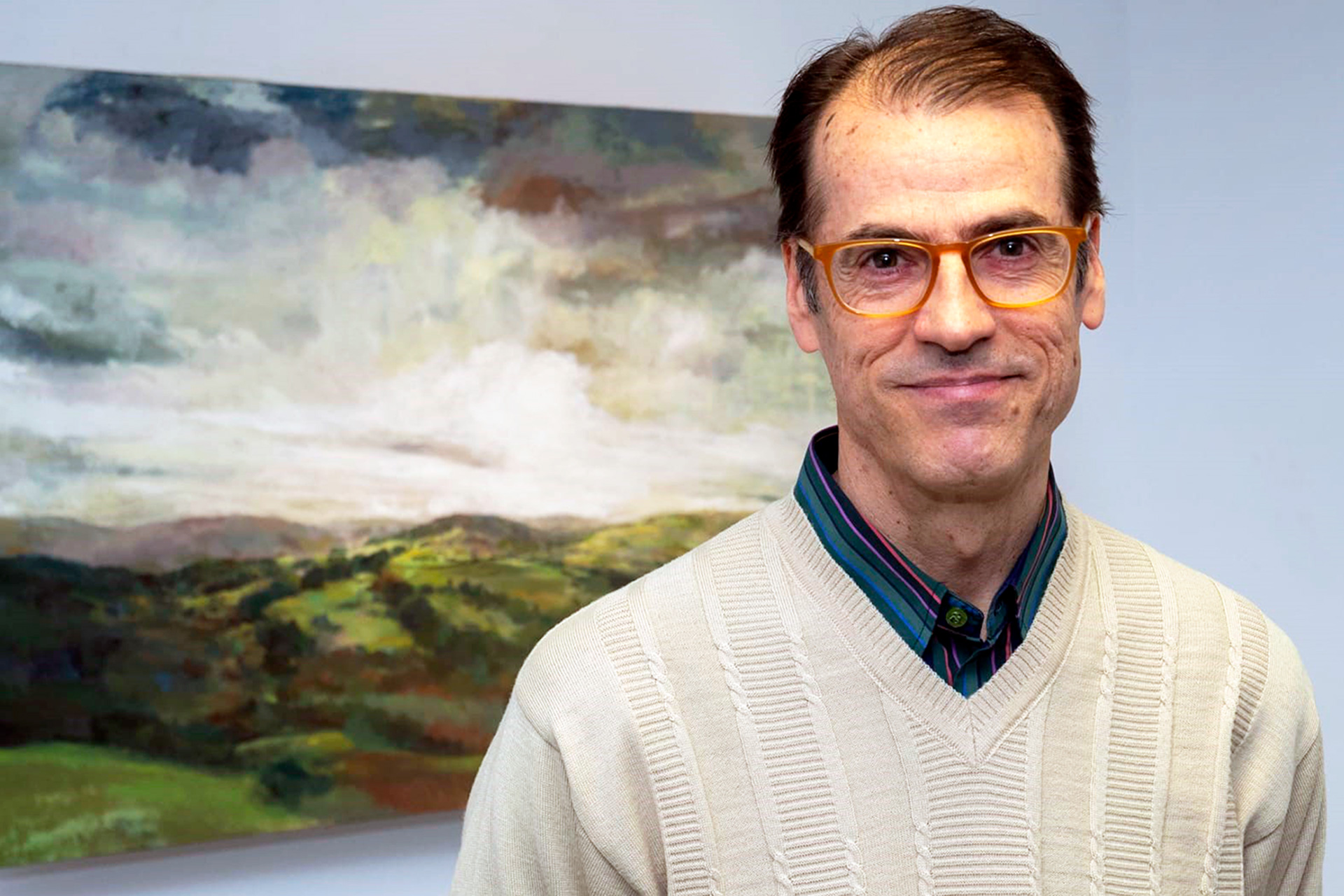 Acinas posa en la exposición con el fondo de una de las obras que pueden verse en la muestra./EL ADELANTADO