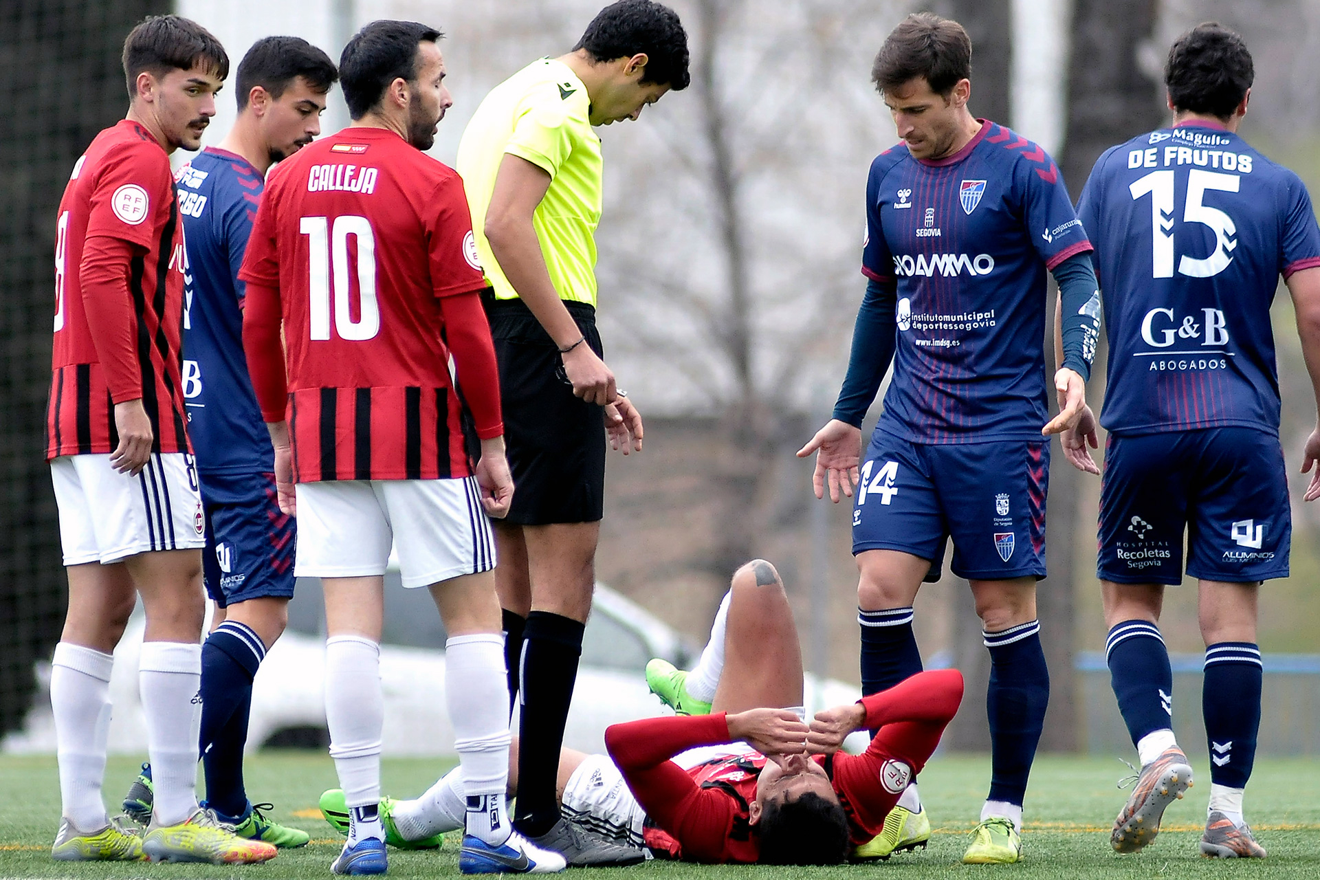 El jugador del Adarve se duele en el suelo mientras Óscar de Frutos se marcha tras ser amonestado./ JUAN MARTÍN-G. SEGOVIANA