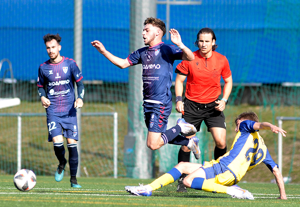 Ivo recibe la falta de un jugador del Alcorcón B durante el encuentro jugado en el Anexo al campo de Santo Domingo. / JUAN MARTÍN-G. SEGOVIANA