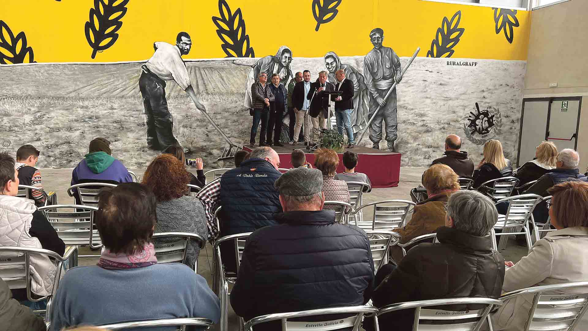 Un mural sobre el pasado agrícola de la localidad sirve de telón de fondo en el centro cultural. / E. A.