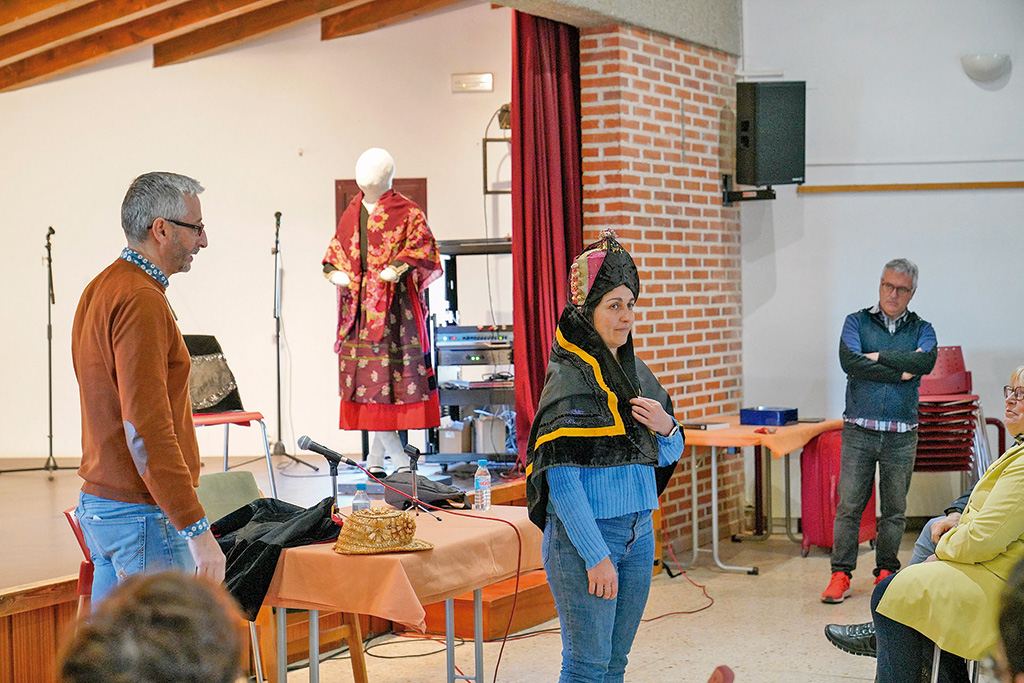 Taller de tocados en la tradición segoviana, a cargo de Carlos del Peso y, de fondo, indumentaria local. / Miguel Ángel Fernández