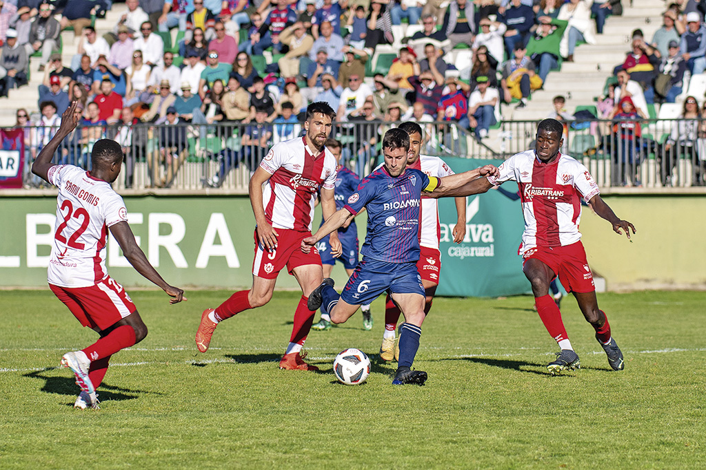 Manu, rodeado de contrarios, intenta el lanzamiento a portería durante el encuentro frente al Cacereño./ LUIS HORCAJADA
