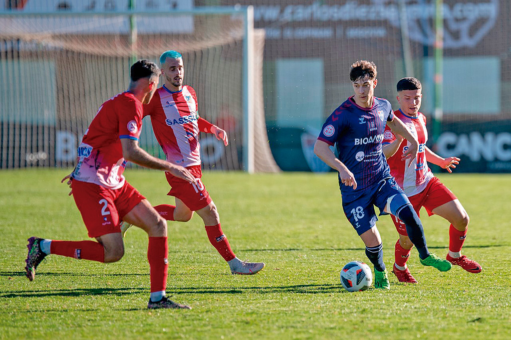 Dani Plomer, rodeado de contrarios durante el partido jugado por la Segoviana frente al Navalcarnero./ LUIS HORCAJADA