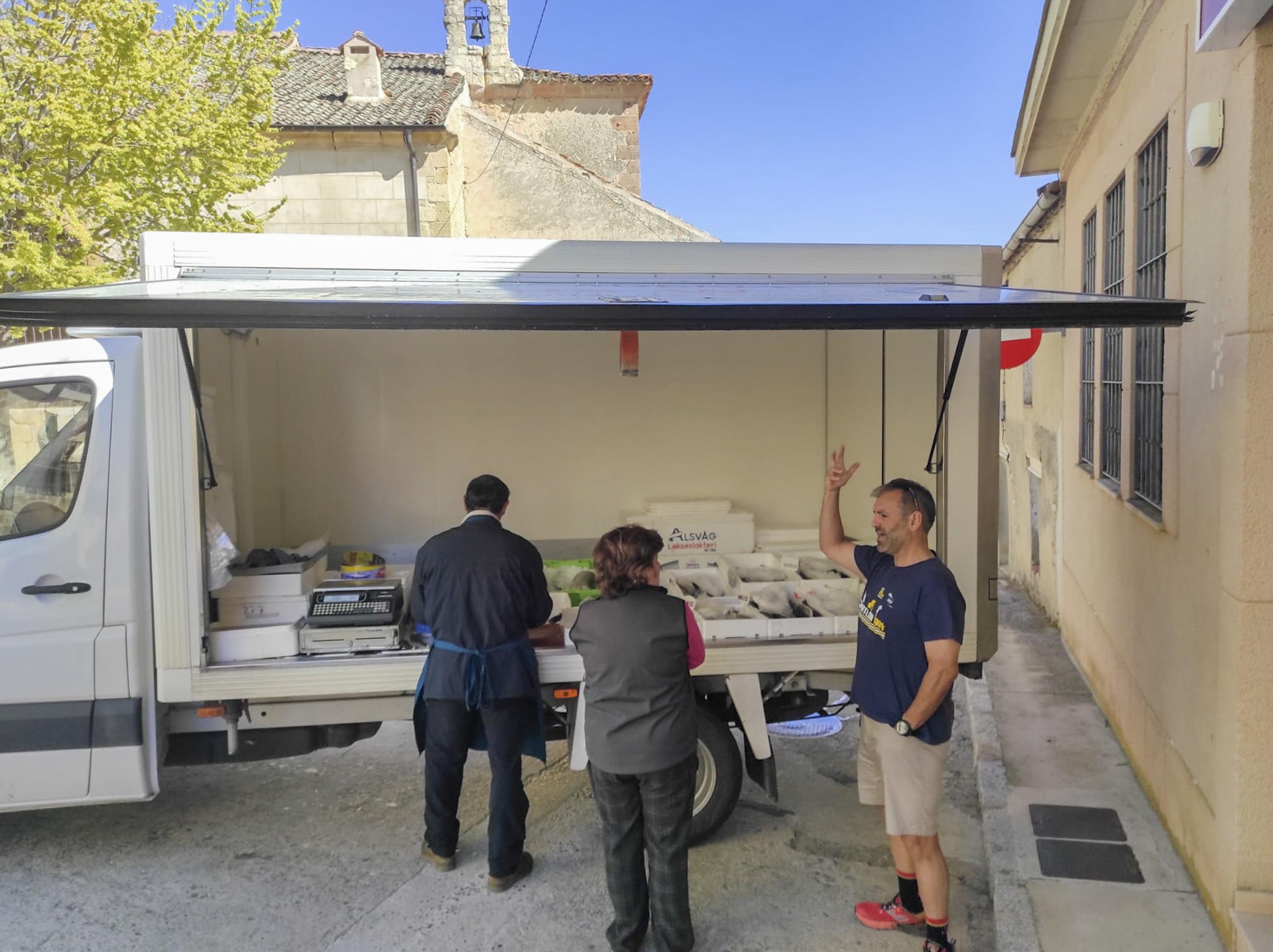 Valentín Peña atiende a clientes que acuden a comprar pescado a su furgón ambulante en Muñoveros. / JJ Ríos (EFE)