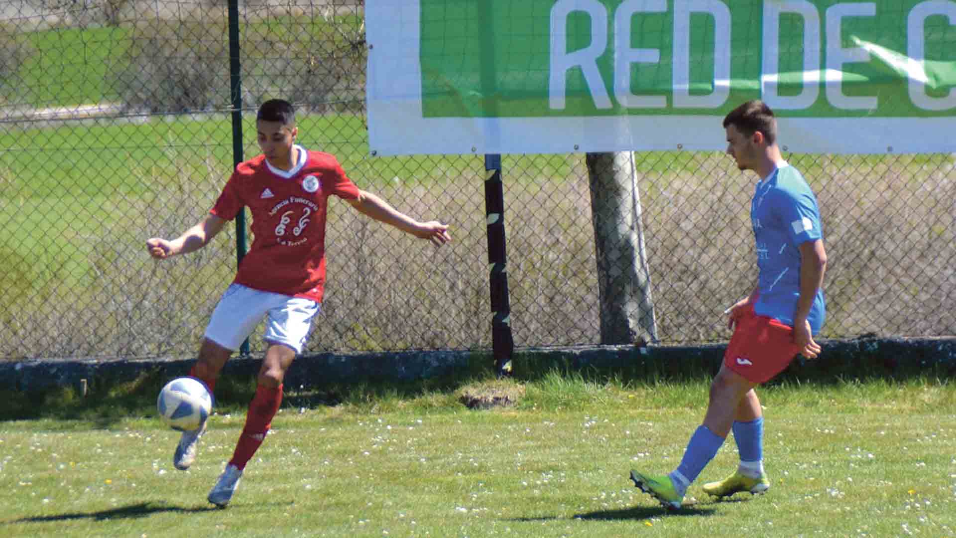 El cuellarano Sebas despeja el balón ante la presión de un jugador del Abejar./ DANIEL MARTÍN