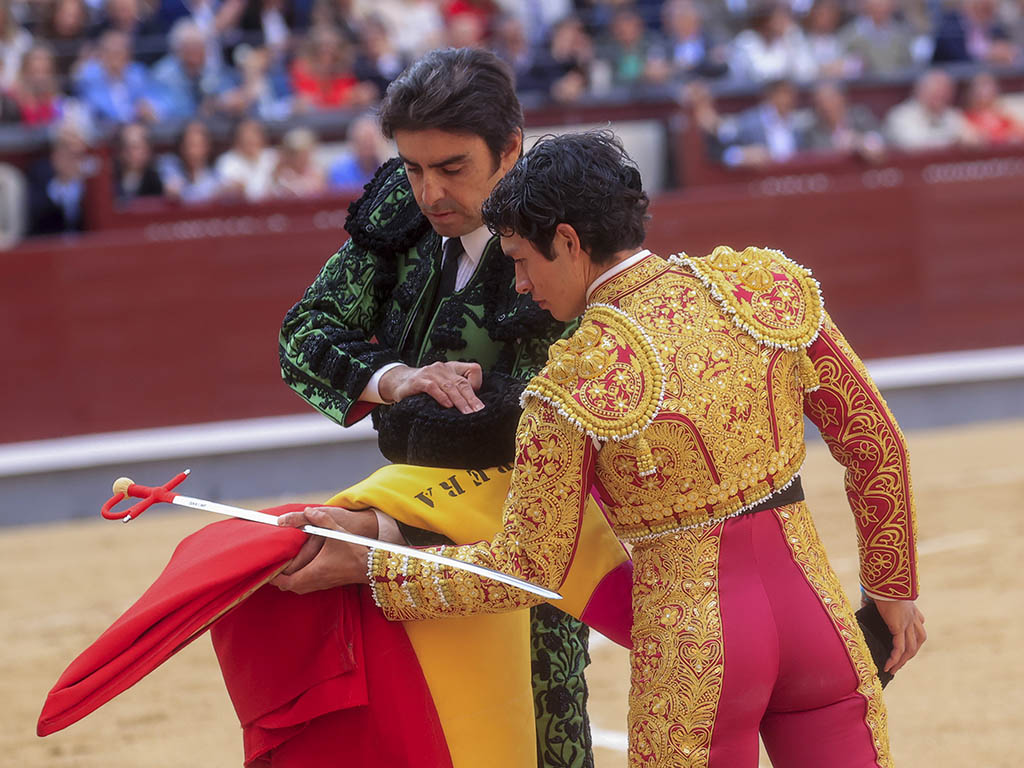 El torero mexicano Isaac Fonseca (d) confirma la alternativa de manos de Miguel Ángel Perera (i) durante el festejo taurino de la Feria San Isidro este lunes en la Monumental de las Ventas, con astados para los diestros Miguel Ángel Perera, Angel Téllez e Isaac Fonseca. EFE/ Zipi