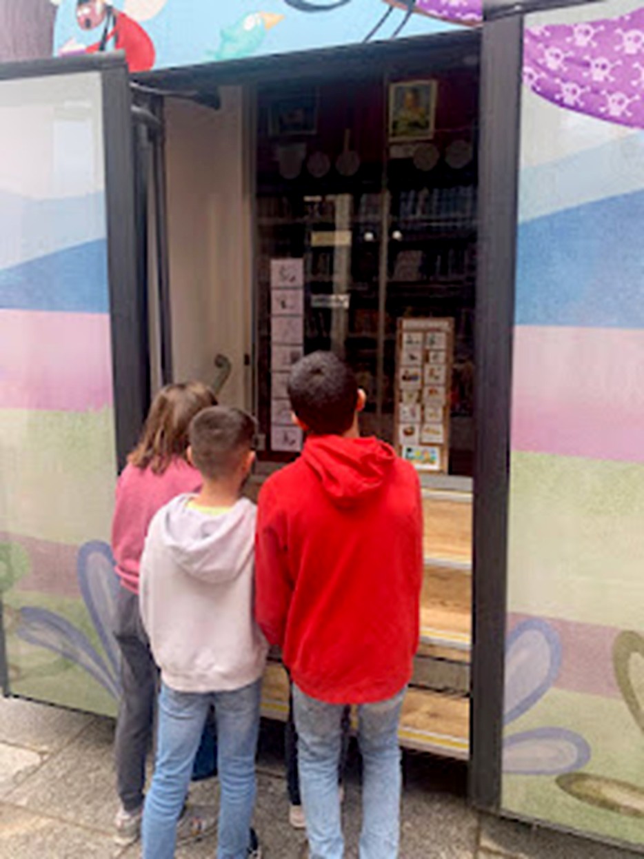Varios alumnos observan los pictogramas colocados en el bibliobús. / E. A.