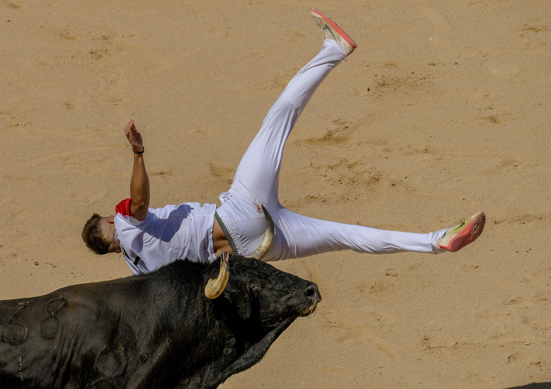 El recortador Cristian Rubio es cogido por un toro durante el Concurso Nacional de recortadores disputado este sábado en el coso pamplonica. / Eloy Alonso (EFE)