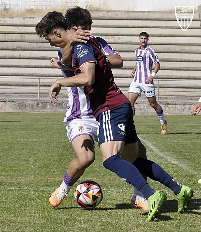 El jugador del Valladolid B frena la progresión de Plomer./ JUAN MARTÍN-G. SEGOVIANA