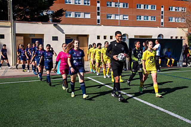 Las futbolistas de la Gimnástica Segoviana y el CD Quintanar, saltando al campo./ MIGUEL ÁNGEL FERNÁNDEZ