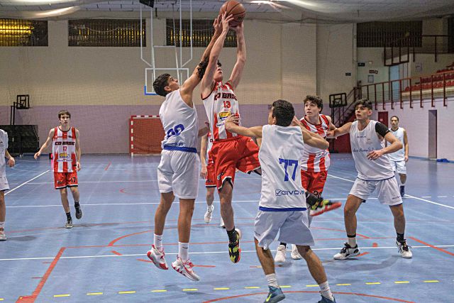 El jugador del CD Base lanza a canasta ante la oposición de un rival./ NEREA LLORENTE
