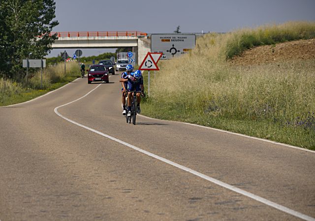 Ciclistas transitando por una carretera segoviana durante el transcurso de la Vuelta a los Pinares./ MIGUEL ÁNGEL FERNÁNDEZ