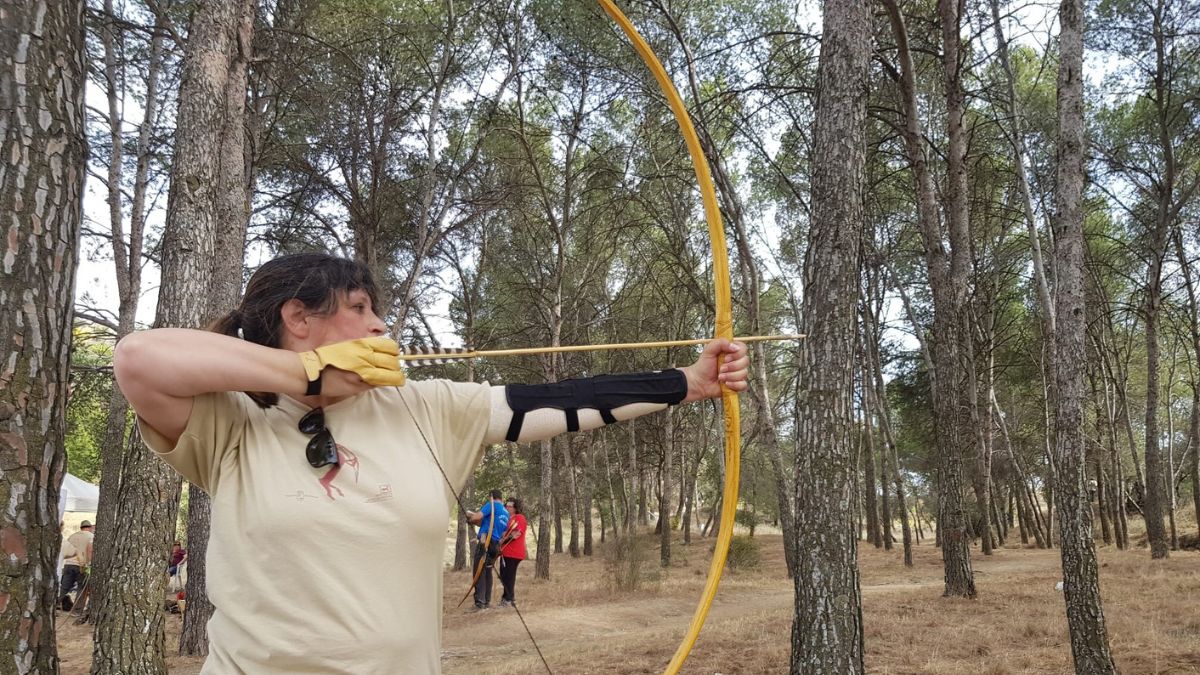 Una competidora, con un arco prehistórico.