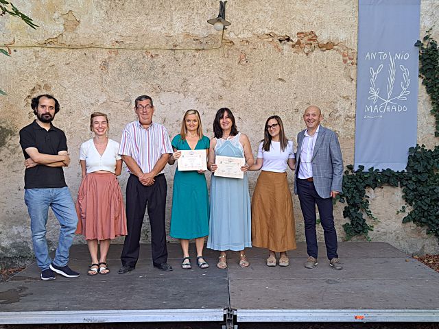 Las dos ganadoras posan con sus diplomas junto a los representantes de los premios.