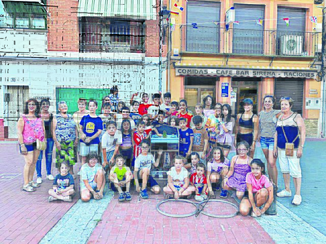 Representantes de la organización, junto a un grupo de participantes posan con algunos juegos. / Lourdes Matarranz