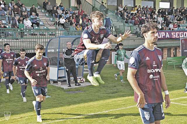Dani Plomer salta durante la entrada al campo de los jugadores de la Segoviana en los prolegómenos de un partido./ JUAN MARTÍN-G. SEGOVIANA