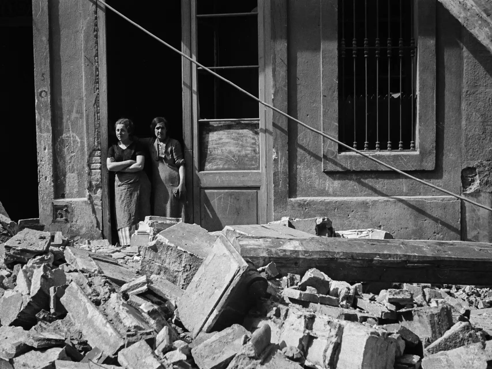 Dos mujeres observan los efectos de un bombardeo. Antoni Campañà. Editorial Comanegra.