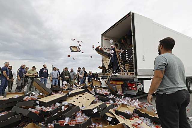 Viticultores franceses destruyen un envío de tomates procedentes de España durante una manifestación en el peaje de Le Boulou, cerca de la frontera española, al sur de Francia, este jueves. Viticultores y enólogos de del sur de Francia protestan contra la introducción de vinos españoles. EFE/EPA/Guillaume Horcajuelo