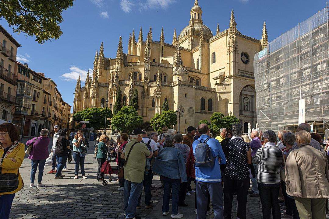 Un grupo de turistas observa la Catedral de Segovia.