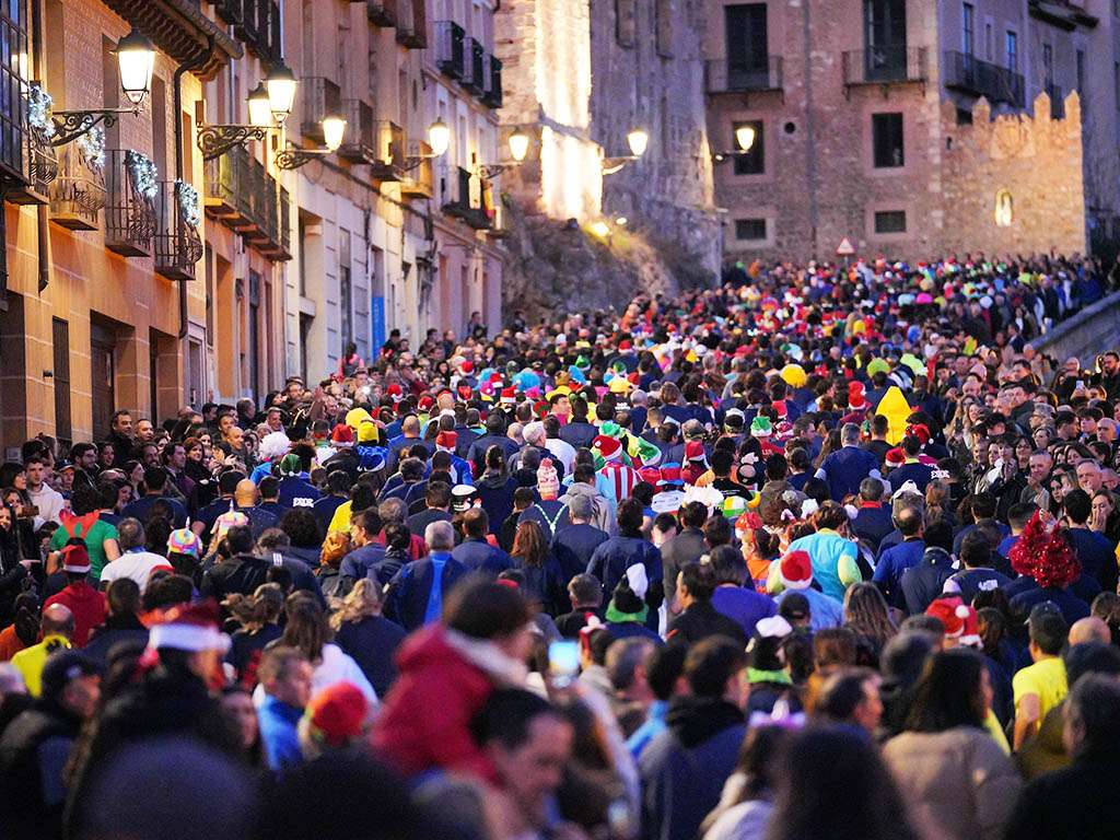 Cientos de corredores suben la calle San Juan de Segovia, durante la pasada edición de Carrera Fin de Año. / MIGUEL ÁNGEL FERNÁNDEZ