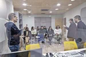 Explicación teórica en el locutorio de radio./ Estudiantes del máster con los profesores coordinadores del taller de radio. / Francisco Fernández-Cueto