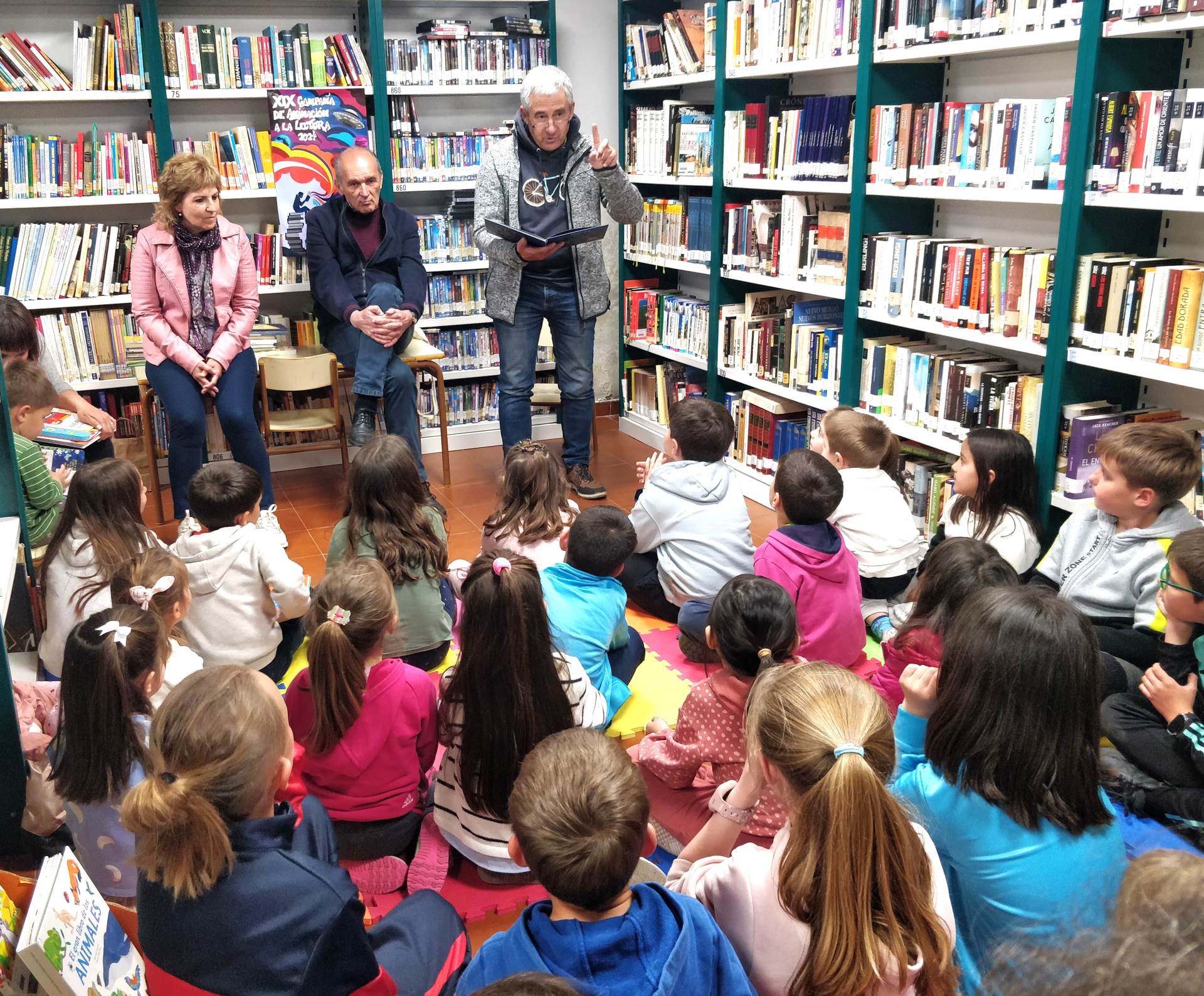 Uno de los narradores de ‘Déjame que te cuente’ lee un cuento ante la atenta mirada de los niños.