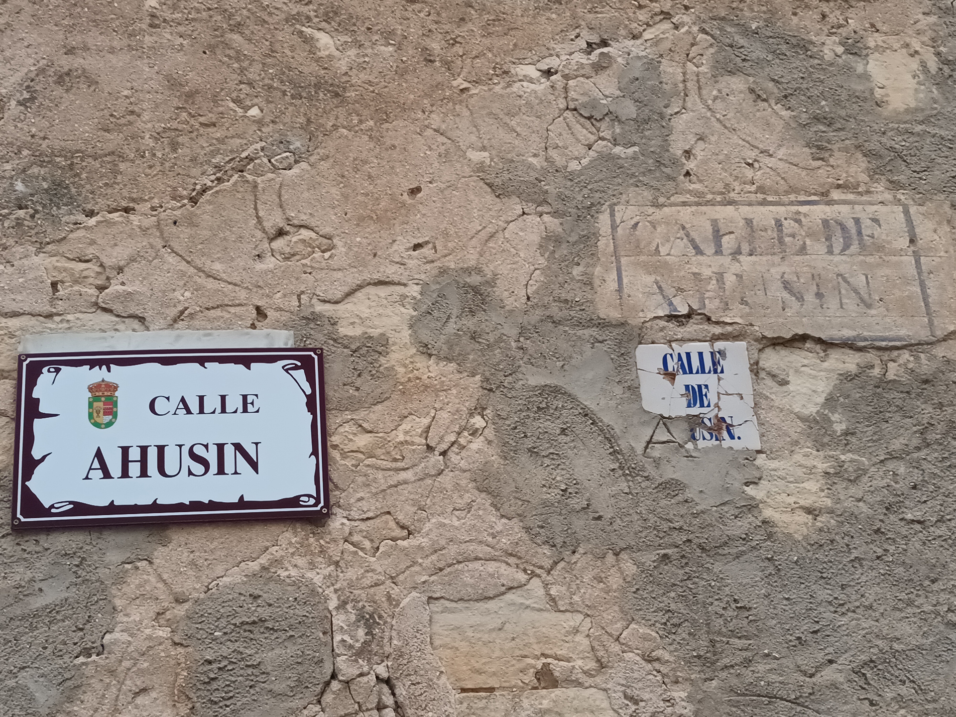 En la calle de Ahusín se pueden observar tres modelos de cartelas del callejero a través de los años.