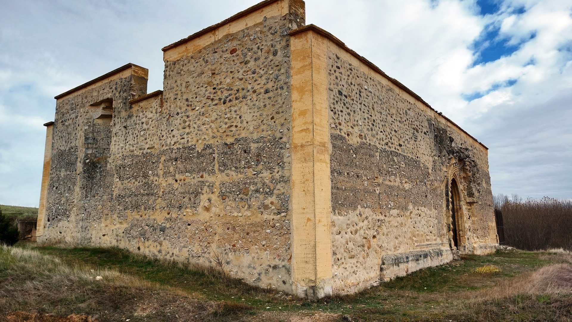 Vista exterior de la ermita desde el ángulo suroeste, donde se aprecia la fachada del mediodía con su portada (arquivoltas en zigzag e impronta del antecuerpo). Vista exterior de la ermita desde el ángulo suroeste, donde se aprecia la fachada del mediodía con su portada (arquivoltas en zigzag e impronta del antecuerpo).