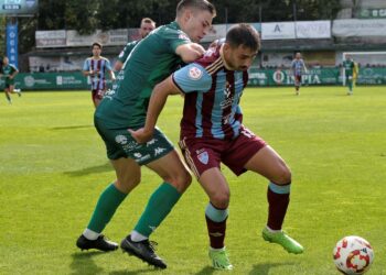 Davo intenta proteger el balón ante la presión insistente de un contrario durante el encuentro jugado en Ourense./ JUAN MARTÍN-G. SEGOVIANA